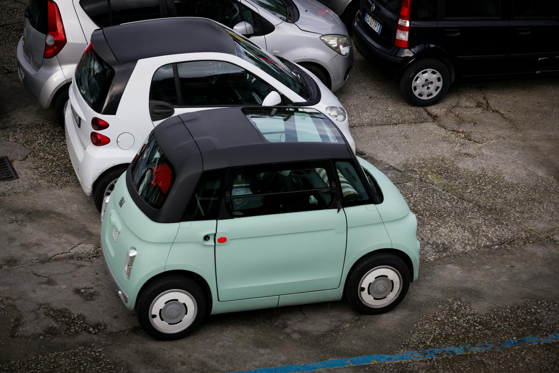 Kompaktowe samochody zaparkowane ciasno na miejskim parkingu plenerowym
